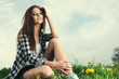 Portrait of young beautiful brunette woman  sitting on grass