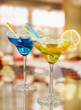Yellow and blue cocktails in glasses on room background