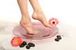 Foto: Female feet in spa bowl with water, isolated on white Female feet in spa bowl with water, isolated on white