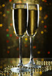 Photo: Two glasses of champagne on bright background with lights Two glasses of champagne on bright background with lights