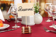 Reserved sign on restaurant table with empty dishes and glasses