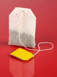 Tea bag on red background