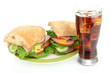 Foto: Tasty ham sandwich and glass of cola with ice isolated on white Tasty ham sandwich and glass of cola with ice isolated on white