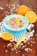 Useful oatmeal in bowl with fruit on wooden table close-up