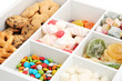 Multicolor candies and cookies in white wooden box close up