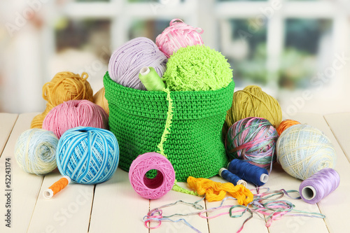 Photo: Colorful yarn for knitting in green basket Colorful yarn for knitting in green basket
