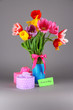 Beautiful tulips in bouquet with gifts and note