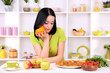 Pretty girl selects pizza or diet on kitchen background