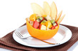 Fruit salad in hollowed-out orange isolated on white
