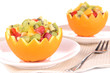 Photo: Fruit salad in hollowed-out orange isolated on white Fruit salad in hollowed-out orange isolated on white