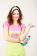 Young housewife with cleaner and sponge on grey background