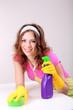 Photo: Young housewife cleaning up table at home on grey background Young housewife cleaning up table at home on grey background