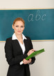 Portrait of teacher woman near chalkboard in classroom