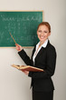 Portrait of teacher woman near the chalkboard in classroom