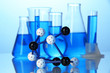 Molecule model and test tubes with liquid on blue background