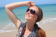 Foto: Beautiful redhead young woman at the beach, looking up Beautiful redhead young woman at the beach, looking up