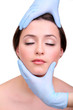 Rubber gloves touching face of young woman close up