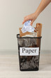 Photo: Assorted trash in bucket on room background Assorted trash in bucket on room background
