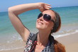 Foto: Beautiful redhead young woman at the beach, looking up Beautiful redhead young woman at the beach, looking up
