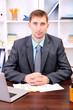 Photo: Young businessman in office at his workplace Young businessman in office at his workplace