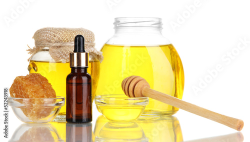 Photo: Fragrant honey spa with oils and honey isolated on white Fragrant honey spa with oils and honey isolated on white