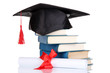 Grad hat with diploma and books isolated on white