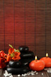 Spa stones with flowers and candles on bamboo background