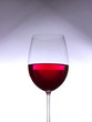 Glass with red wine on gray-white gradient background