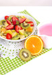 Useful fruit salad of fresh fruits and berries in bowl isolated