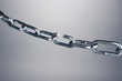 Broken chain on gray background