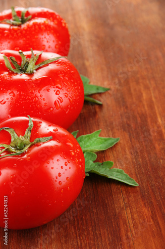 Photo: Fresh tomatoes on wooden background Fresh tomatoes on wooden background