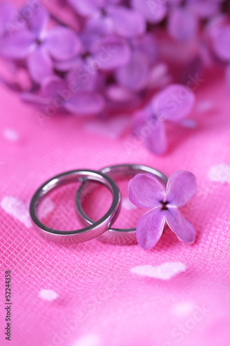 Photo: Beautiful wedding rings on pink background Beautiful wedding rings on pink background