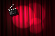 Movie clapper board against curtain