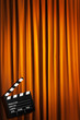Movie clapper board against curtain