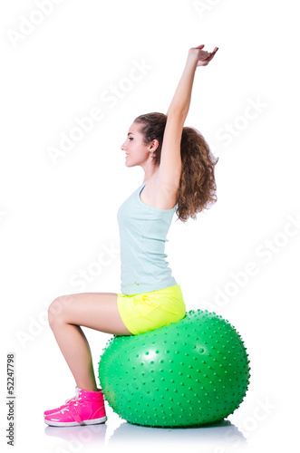 Photo: Young woman with ball exercising on white Young woman with ball exercising on white