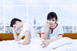 Couple fight on bed in apartment
