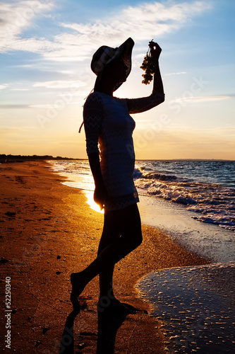 Photo: silhouette of sexy girl in hat holding grapes silhouette of sexy girl in hat holding grapes