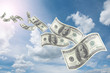 flying dollar bills in flocks in blue sky