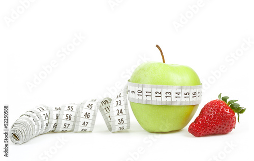 Photo: Measuring tape wrapped around a green apple as a symbol of diet Measuring tape wrapped around a green apple as a symbol of diet