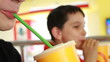 Portrait of happy little boy drinking orange juice.