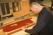 man hammers wooden dowels into the wood