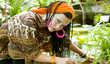 Blue-eyed woman with the african pigtails among tropical plants
