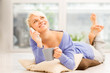 Smiling woman with mug on the floor while phoning