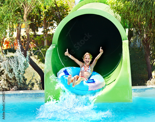 Photo: Child on water slide at aquapark. Child on water slide at aquapark.