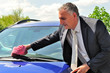 Photo: Man wearing suit cleaning a car. Man wearing suit cleaning a car.