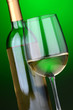 A glass of white wine and wine bottle