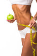 Healthy female body with apple and measuring tape