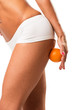 A young girl in underwear with an orange on a white background