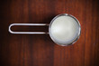 Milk in small metal pot, for heating liquids, on dark wood