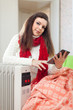 woman reads e-book near  heater